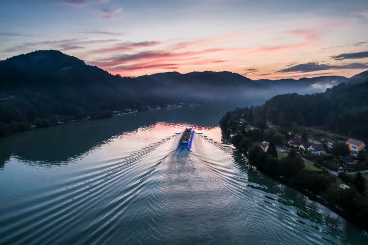 Uniworld river cruise ship sailing into the sunset